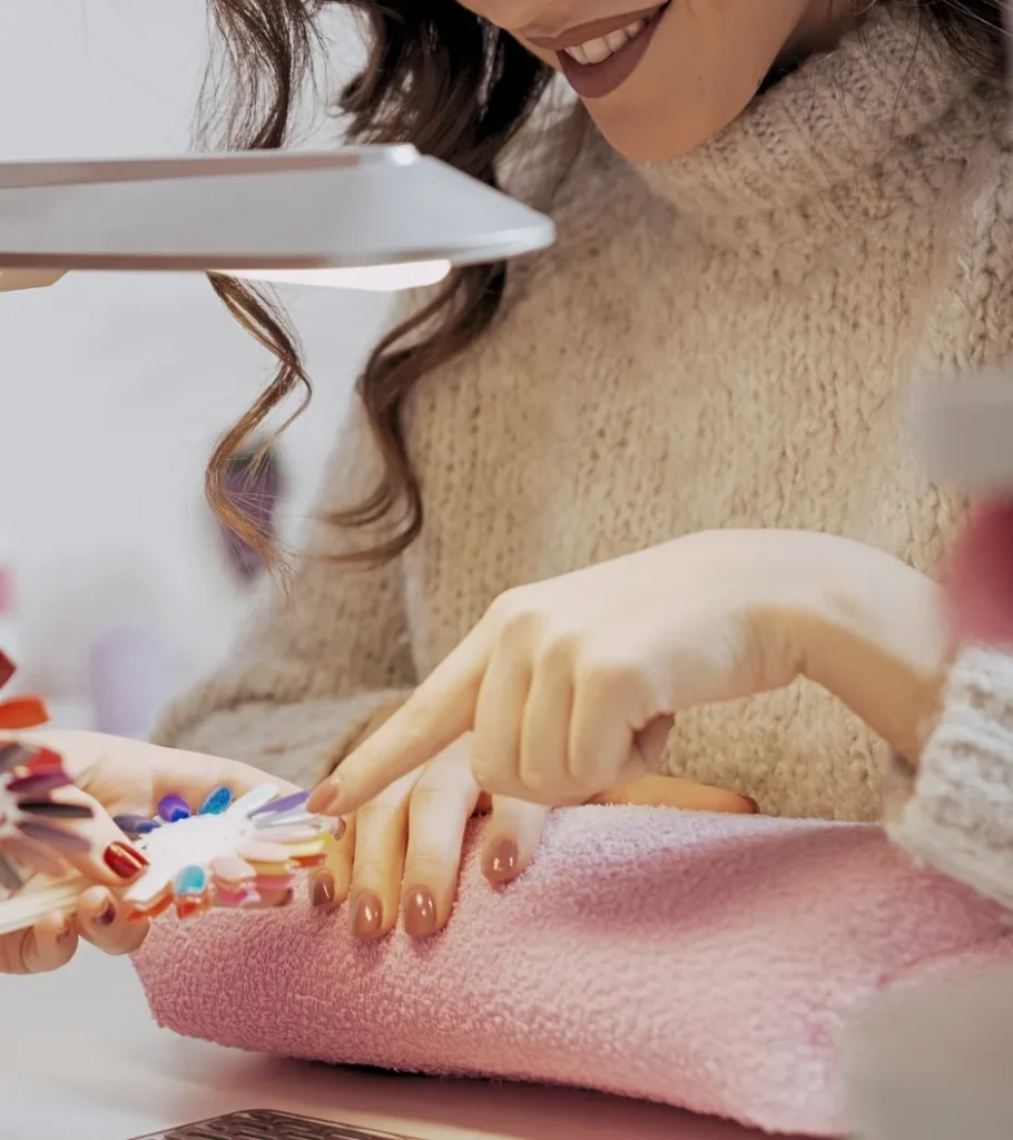 Close-up of a smiling client picking a color from a swatch wheel for her long-lasting gel manicure at Moiselle, a top-rated nail studio in Canggu, Bali.